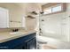 Well-lit bathroom boasts a single vanity and a shower-tub combo, complemented by floating shelves at 42616 W Avella Dr, Maricopa, AZ 85138