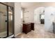 This bathroom has an open vanity area with a walk-in shower and a neutral tile floor at 42616 W Avella Dr, Maricopa, AZ 85138