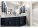 Modern bathroom features double vanity with dark cabinets, white countertops, and stylish fixtures at 42616 W Avella Dr, Maricopa, AZ 85138