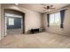 This bedroom offers great light with a ceiling fan and a view into another room at 42616 W Avella Dr, Maricopa, AZ 85138