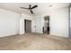 This large bedroom features neutral paint and carpet with an ensuite bathroom and closet at 42616 W Avella Dr, Maricopa, AZ 85138