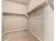 This is a simple closet featuring neutral paint and a wooden clothes bar at 42616 W Avella Dr, Maricopa, AZ 85138
