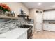 Modern kitchen with sleek stainless steel appliances, stylish tile backsplash, and ample counter space at 42616 W Avella Dr, Maricopa, AZ 85138