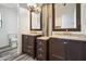 Bathroom with dual vanity sinks, wood-style flooring, and wood-framed mirrors at 45647 W Starlight Dr, Maricopa, AZ 85139