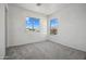 Bright bedroom features neutral carpet, white walls and two windows for natural light at 45647 W Starlight Dr, Maricopa, AZ 85139