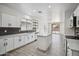 Modern kitchen featuring white cabinets, black backsplash, stainless steel appliances, and an island with counter seating at 45647 W Starlight Dr, Maricopa, AZ 85139