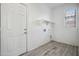 Bright laundry room featuring tile floors, shelving, and washer/dryer hookups at 45647 W Starlight Dr, Maricopa, AZ 85139