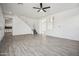 Open-concept living room featuring wood-look tile flooring, neutral decor, and staircase access to upper level at 45647 W Starlight Dr, Maricopa, AZ 85139