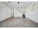 Spacious living room with wood-look tile flooring, white walls, staircase and ample natural light at 45647 W Starlight Dr, Maricopa, AZ 85139