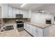 Updated kitchen with granite counters, stainless steel appliances, and a view of the fireplace at 4601 N 102Nd Ave # 1020, Phoenix, AZ 85037