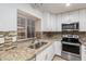 Bright kitchen featuring granite countertops, stainless steel appliances, and white cabinetry at 4601 N 102Nd Ave # 1020, Phoenix, AZ 85037