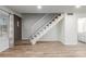 Open-concept living area with tile floors, staircase and a view of the front door and white cabinets at 4601 N 102Nd Ave # 1020, Phoenix, AZ 85037