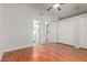 Spacious main bedroom featuring wood floors, ceiling fan, and convenient access to the bathroom and laundry at 4601 N 102Nd Ave # 1020, Phoenix, AZ 85037