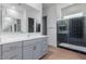 Modern bathroom featuring double sinks, and a walk-in shower with black tile at 5139 N 185Th Ave, Litchfield Park, AZ 85340