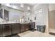 Bright bathroom features double sinks with dark cabinets and a tiled walk-in shower at 5316 N 186Th Dr, Litchfield Park, AZ 85340