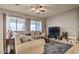 Comfortable living room with plush sofa, large windows, ceiling fan, and neutral decor at 5316 N 186Th Dr, Litchfield Park, AZ 85340