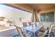 Covered outdoor patio featuring a dining table set and comfortable seating area at 5316 N 186Th Dr, Litchfield Park, AZ 85340