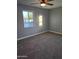 This cozy bedroom features plush carpeting, a ceiling fan, and a bright window offering natural light at 6216 S 5Th Ave, Phoenix, AZ 85041