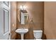 Half bath featuring oval mirror, pedestal sink and toilet on brown walls with textured finish at 645 W Longhorn Dr, Chandler, AZ 85286