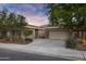 Charming single-story home with a well-manicured yard and a spacious two-car garage at dusk at 645 W Longhorn Dr, Chandler, AZ 85286