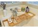 A detailed shot of a bathtub with a bamboo tray, bath essentials, and decorative accents at 7027 W Blackhawk Dr, Glendale, AZ 85308