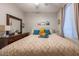 Bright bedroom featuring a bed with decorative pillows, large dresser, and sunny window at 7027 W Blackhawk Dr, Glendale, AZ 85308