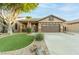 Charming single-story home with a well-manicured lawn, desert landscaping, and a two-car garage at 7027 W Blackhawk Dr, Glendale, AZ 85308