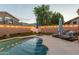 Outdoor pool area featuring a covered patio, lounge chairs, and ambient string lights, ideal for entertaining at 7027 W Blackhawk Dr, Glendale, AZ 85308