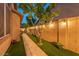 This side yard features a stone path, synthetic grass, and beautiful green trees at 7027 W Blackhawk Dr, Glendale, AZ 85308