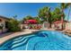 Backyard pool with lounge chairs, shade umbrellas, and mature landscaping at 717 N Mckemy Ave, Chandler, AZ 85226