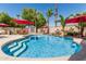 Sparkling blue swimming pool with tanning ledge and sun umbrellas, creating a serene outdoor retreat at 717 N Mckemy Ave, Chandler, AZ 85226