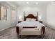 A spacious main bedroom boasts a wood bed frame and floors, with a comfortable bench at the foot at 723 E Gemini Pl, Chandler, AZ 85249