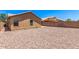 Side view of backyard with desert landscaping, two windows and a sliding glass door at 7419 W Raymond St, Phoenix, AZ 85043