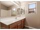 Bathroom showcasing a single sink vanity, large mirror, and natural light at 7419 W Raymond St, Phoenix, AZ 85043