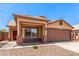 Single-story home featuring desert landscaping, a two-car garage, and a covered porch at 7419 W Raymond St, Phoenix, AZ 85043