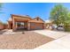 Single-story home featuring a two-car garage, desert landscaping, and a covered porch at 7419 W Raymond St, Phoenix, AZ 85043