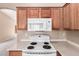 Close-up of stove and microwave with wood cabinets and countertops in this kitchen at 7419 W Raymond St, Phoenix, AZ 85043