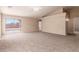 Open living room with neutral carpet, fan, and sliding door access to the backyard patio at 7419 W Raymond St, Phoenix, AZ 85043