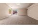Spacious living room with neutral carpet, ceiling fan, and sliding glass doors to the backyard at 7419 W Raymond St, Phoenix, AZ 85043