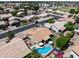 A wider aerial showcasing a home in a neighborhood setting with a pool and patio, great for outdoor living at 7736 W Tumblewood Dr, Peoria, AZ 85382
