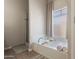 Bathroom featuring a large tub with elegant fixtures, fluffy white towels, and a frosted window at 7736 W Tumblewood Dr, Peoria, AZ 85382