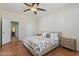 Cozy bedroom featuring a ceiling fan, neutral walls, wood-look flooring, and stylish furnishings at 7736 W Tumblewood Dr, Peoria, AZ 85382