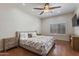 Bedroom with wood floors, large bed, ceiling fan, and window shutters at 7736 W Tumblewood Dr, Peoria, AZ 85382