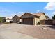 A single-story home with a two-car garage and desert landscaping with paved driveway and sidewalk at 7736 W Tumblewood Dr, Peoria, AZ 85382