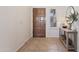 Welcoming foyer with a wood front door, neutral tile flooring, and a decorative console table at 7736 W Tumblewood Dr, Peoria, AZ 85382