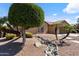 Charming front yard featuring desert landscaping, mature trees, and a decorative stone pathway at 7736 W Tumblewood Dr, Peoria, AZ 85382