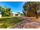 Expansive backyard featuring lush green grass, mature trees, and decorative rock landscaping at 780 W Morelos Ct, Chandler, AZ 85225