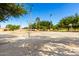 Community basketball court featuring multiple hoops, lighting and a surrounding park with plenty of green space and mature trees at 780 W Morelos Ct, Chandler, AZ 85225