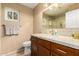 Bathroom with granite counters, wood cabinets, and a decorative mirror at 780 W Morelos Ct, Chandler, AZ 85225