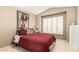 Comfortable bedroom with a red quilt, shuttered window, and neutral-toned walls at 780 W Morelos Ct, Chandler, AZ 85225